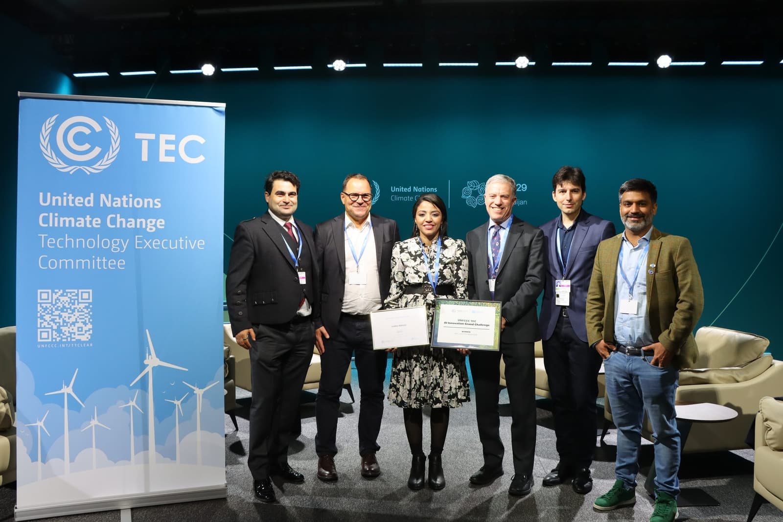 Six people on a COP 29 stage beside a UNFCCC Technology Executive Committee banner, two of them holding the AI Innovation Grand Challenge winner's certificate.